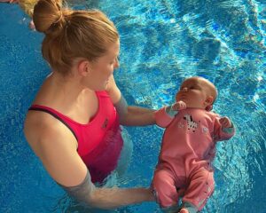 mother in pool with her baby